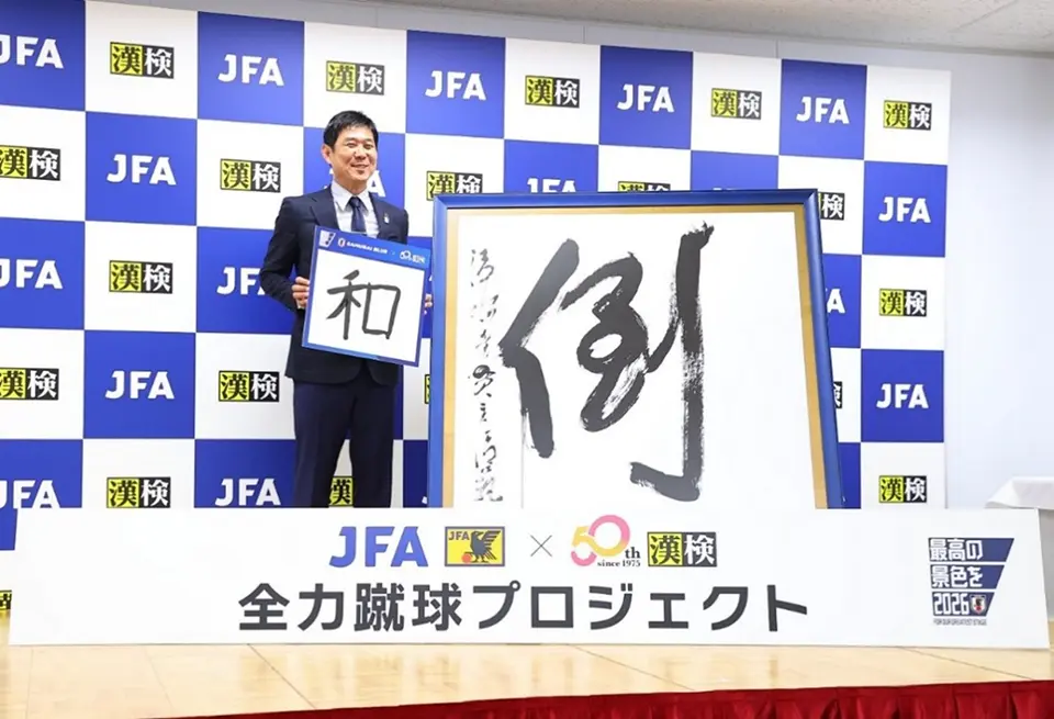 「決意の漢字」『和』を掲げるサッカー日本代表の森保一監督と、1997年「今年の漢字」第一位「倒」大書レプリカ/2025年6月11日撮影